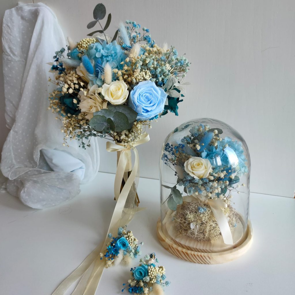 Ramo de novia de flores preservadas en azul y blanco, con réplica en cúpula de cristal